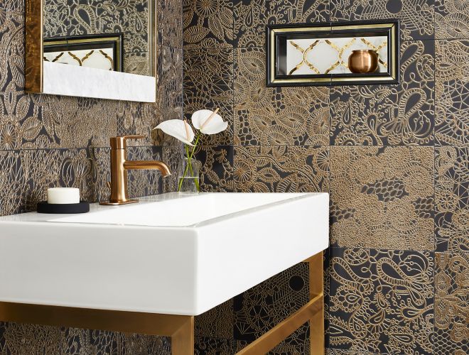 Vanity area with gold and black accent field tile stacked and a decorative niche with mirrored and natural marble tile and like trim tile profiles.