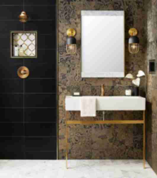 This all-tile bathroom combines multiple styles of black tiles. The vanity wall features a textured gold and black patterned tile, while the adjacent shower wall features oversize black subway tile arranged in a straight horizontal stack.