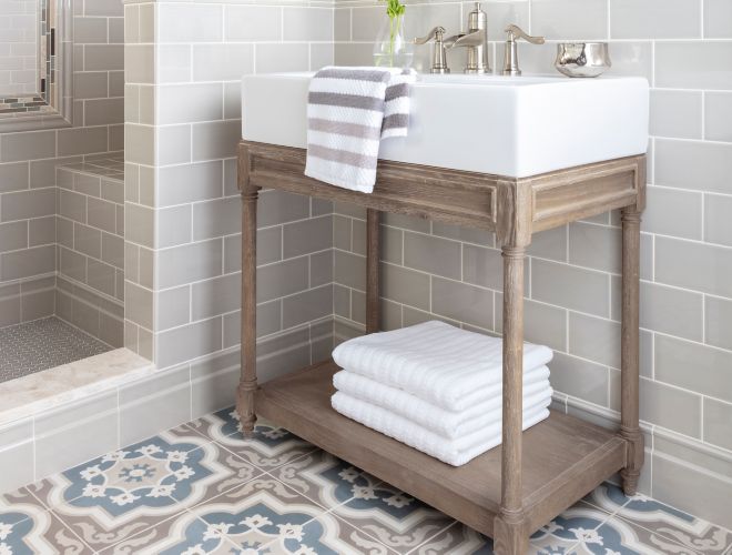 Modern farmhouse bathroom with subway wall tile and brown and blue encaustic floor tile.