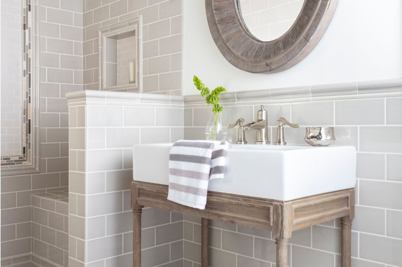 Modern farmhouse bathroom with subway wall tile and brown and blue encaustic floor tile.