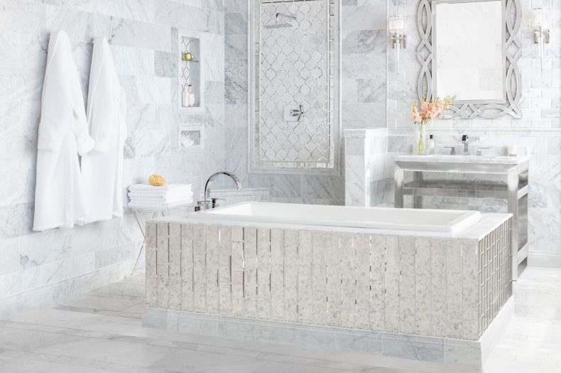 Elegant bathroom with white marble tile and antique mirror accents.