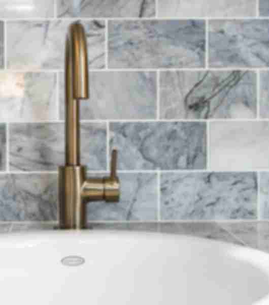 Marble tiles surrounded bathroom wash basin. 