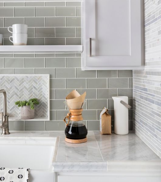 Green glass subway tile kitchen backsplash with herringbone mosaic accent.