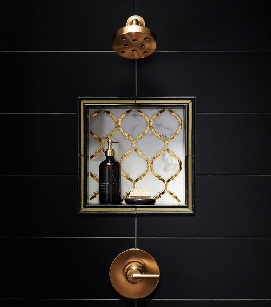 Antique Mirror glass and stone mosaic infuses any design with metallic and reflective elements. black marble contains subtle white veining running throughout to give it that classic marble look and frames gold glass liner perfectly around this shower niche.