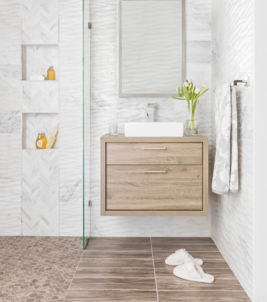 Bathroom with white carrara marble walls and warm wood accents.