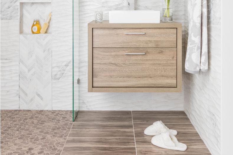 Bathroom with white carrara marble walls and warm wood accents.