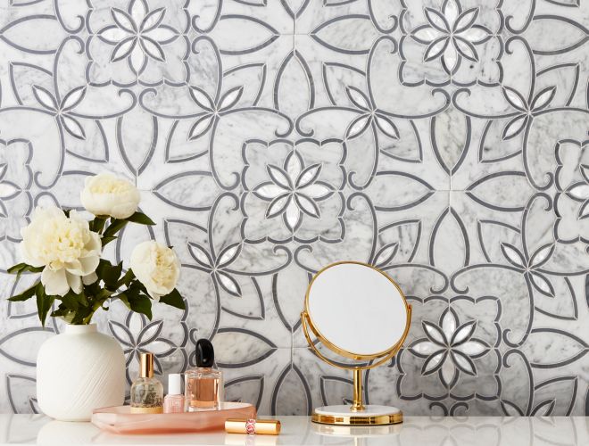 White marble mosaic with grey flower pattern on wall of elegant powder room.