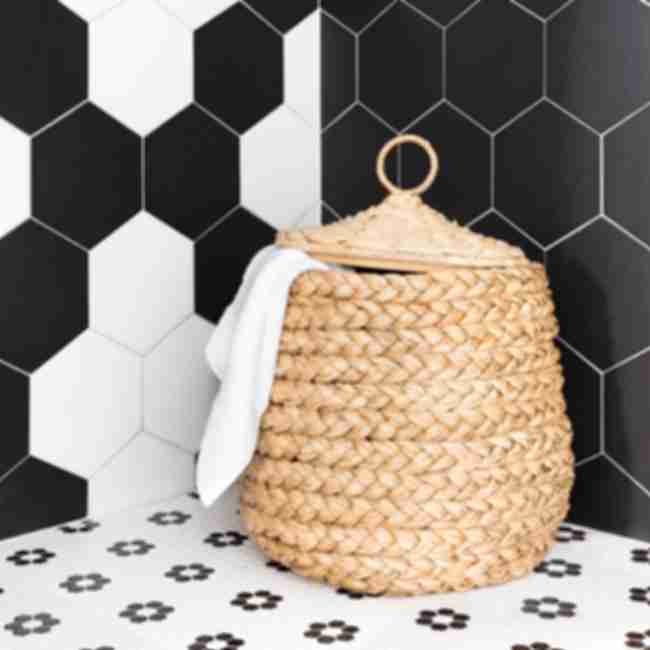 Walk-in shower with large hex on shower walls and a flower pattern black and white hex on the shower floor.