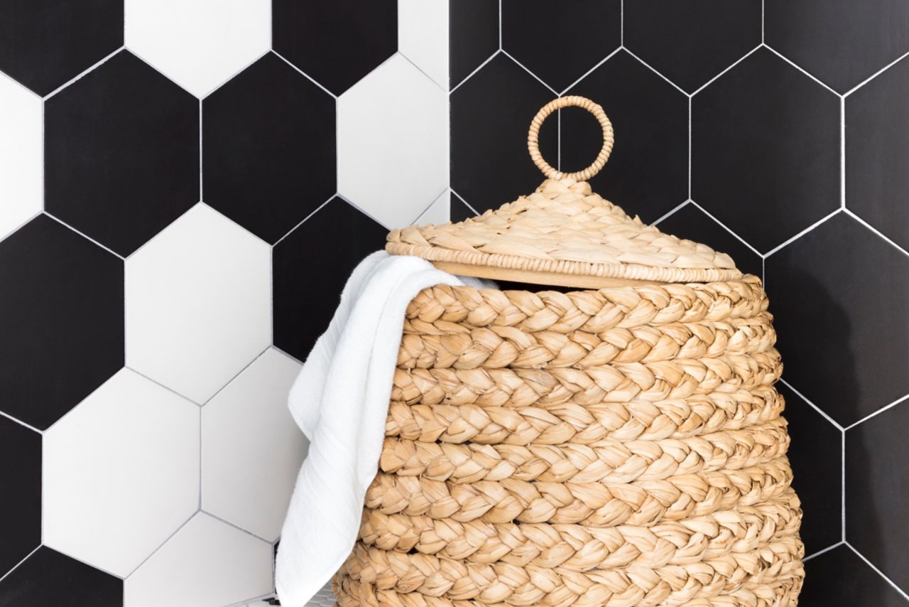 Walk-in shower with large hex on shower walls and a flower pattern black and white hex on the shower floor.