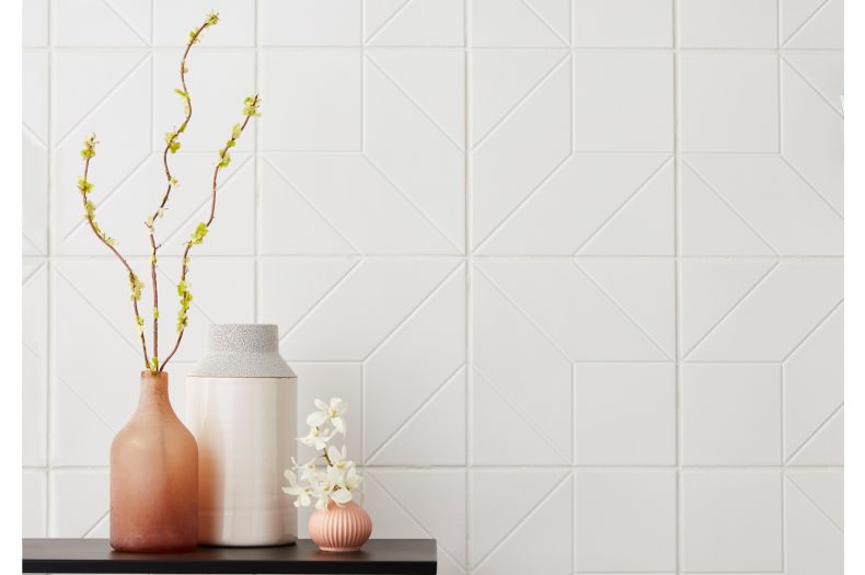 Modern and feminine entry way with white, geometric wall tile.