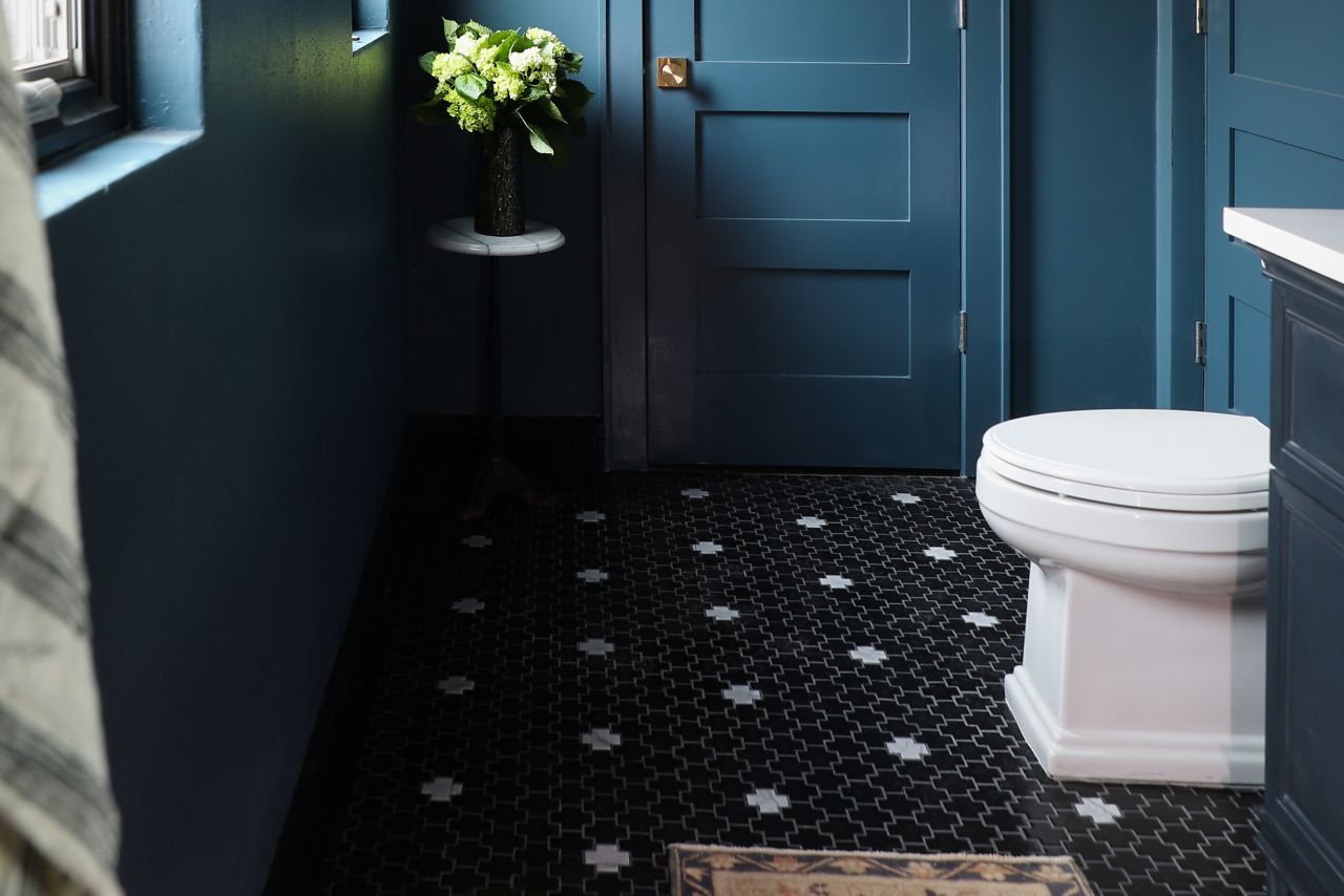 This cool blue bathroom features a black and white cross-shaped tile floor.