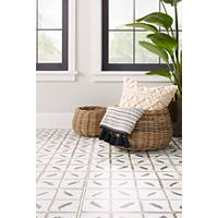 Thumbnail image of This patterned tile on the floor incorporates an Indonesian decorative design that lends a bohemian vibe. Whicker basket sit atop this tile.  
