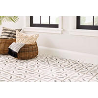 Thumbnail image of This patterned tile on the floor incorporates an Indonesian decorative design that lends a bohemian vibe. Whicker baskets, throw rug and a furry companion sit atop this tile.  