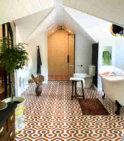 Bathroom with orange, black and white patterned floor tile.