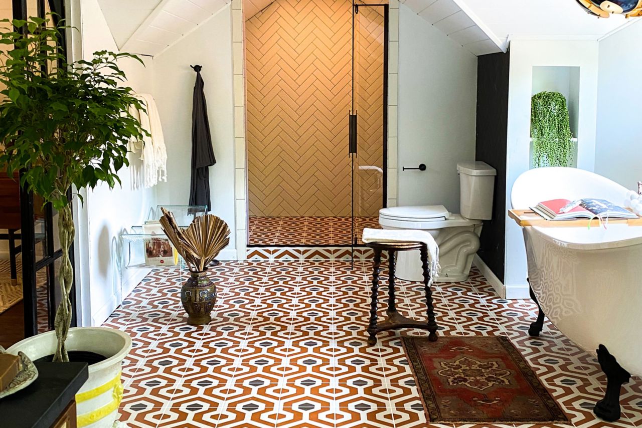 Bathroom with orange, black and white patterned floor tile.