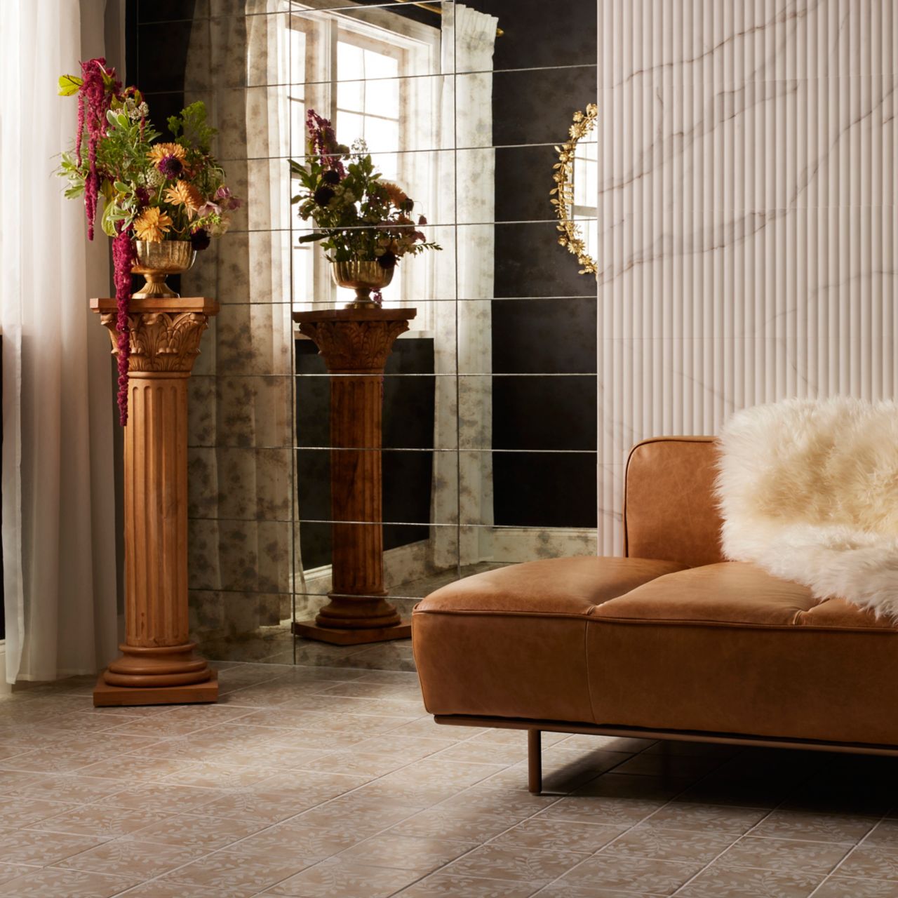 A creative space that features a patterned floor tile and fluted marble-look tile and mirrored wall tile. 