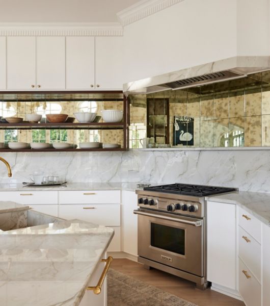 Kitchen with mirrored tile behind open shelving.