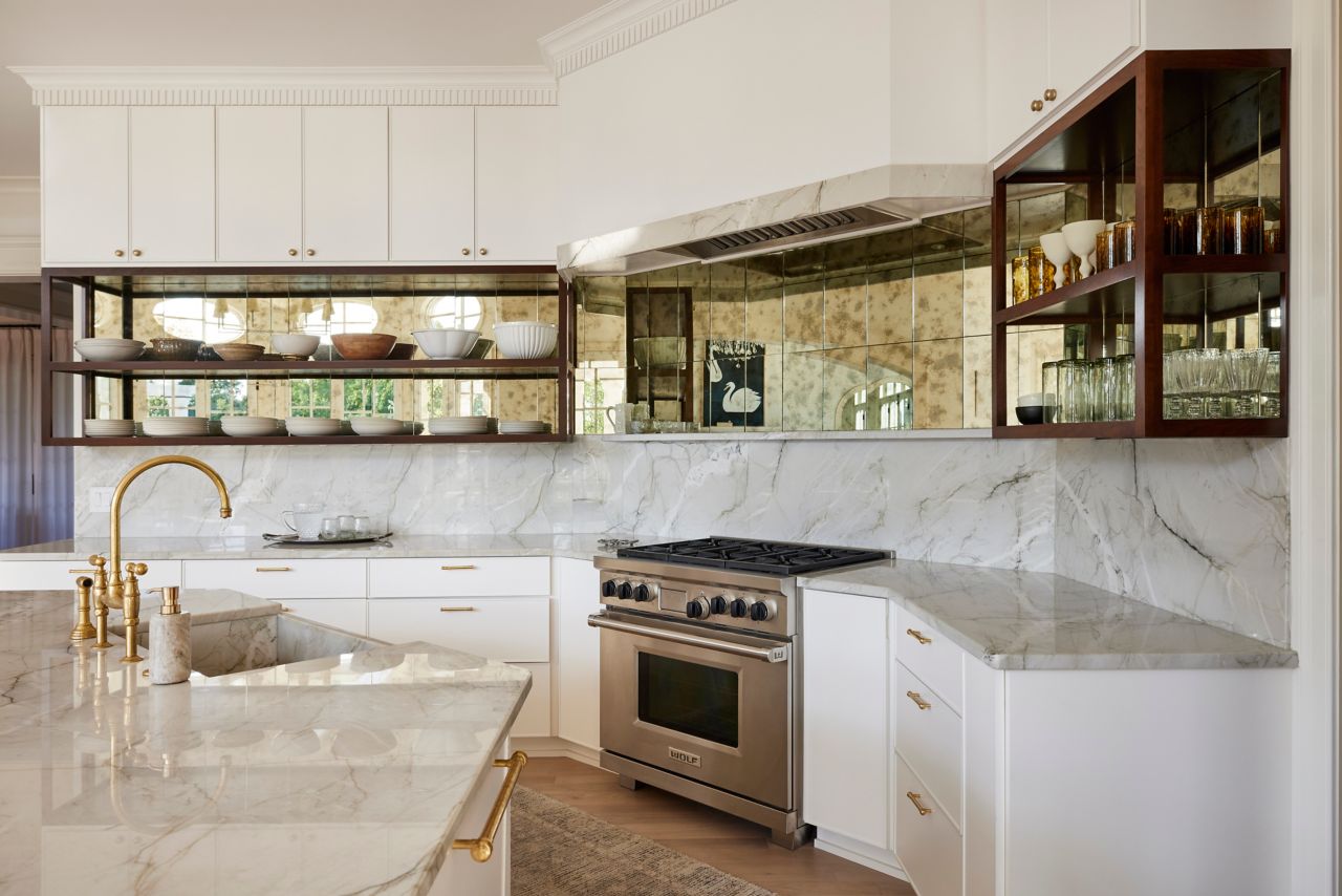 Kitchen with mirrored tile behind open shelving.