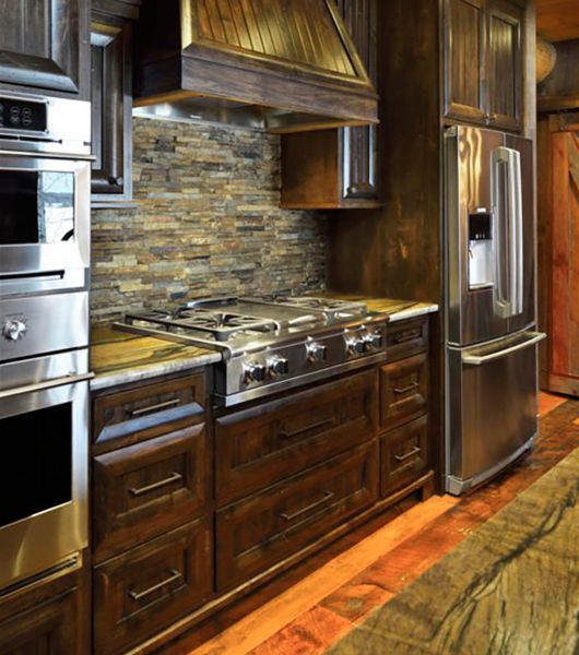 Kitchen with dark cabinets and slate backsplash.