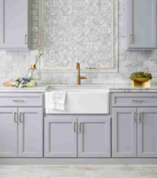 Kitchen with porcelain tile on floor resembling wood planks. Marble counter tops set under a backsplash of marble subway tile accenterd with mother of pearl and marble mosaic deco framed with marble and gold profiles.