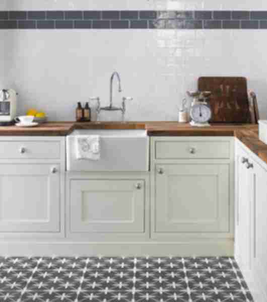 Kitchen area with white subway tile and a blue  border also in this collection.  The floor is a patterned ceramic in charcoal and white.