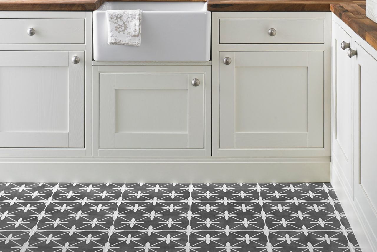 Kitchen area with white subway tile and a blue  border also in this collection.  The floor is a patterned ceramic in charcoal and white.