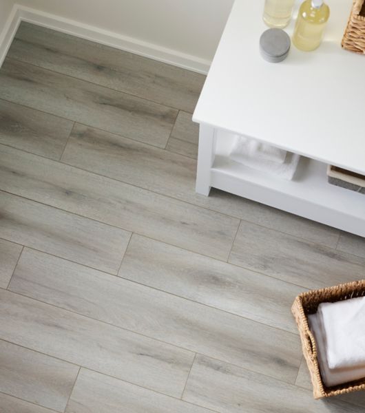 Overhead shot of a table with soaps, basket with towels and wood-look flooring