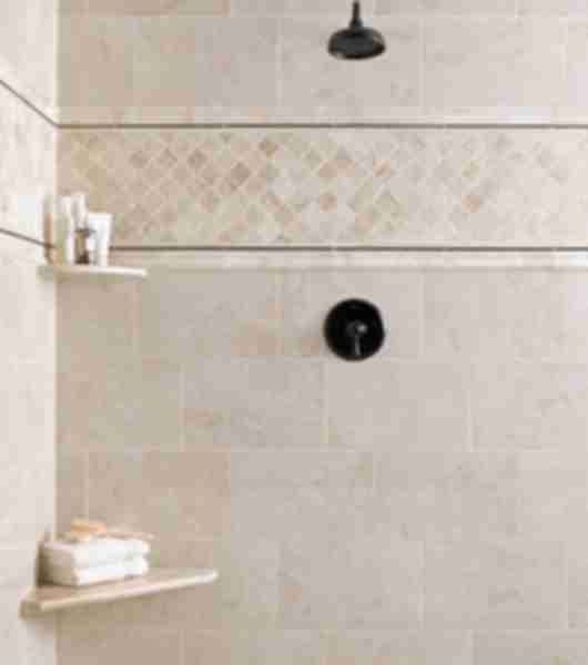 Shower with natural marble mosaics and accessories including corner seat and shelf.  Metal and natural stone profiles frame marble mosaic.  Tile in neutral beige and ivory tones.
