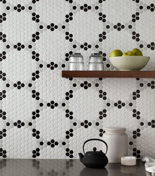 Kitchen wall tile backsplash using mosaic tiles featuring small hexagon-shaped tiles in shades of white, black and grey arranged into large hexagon patterns.