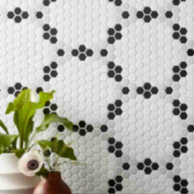 Kitchen wall tile backsplash using mosaic tiles featuring small hexagon-shaped tiles in shades of white, black and grey arranged into large hexagon patterns.