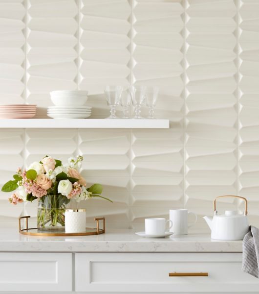 Neutral beige kitchen backsplash featuring sculptural 3x10-inch matte porcelain subway tile with raised angles and facets. The geometric surface lines create elegant texture and dimension that adds personality and movement to this otherwise minimalist space.