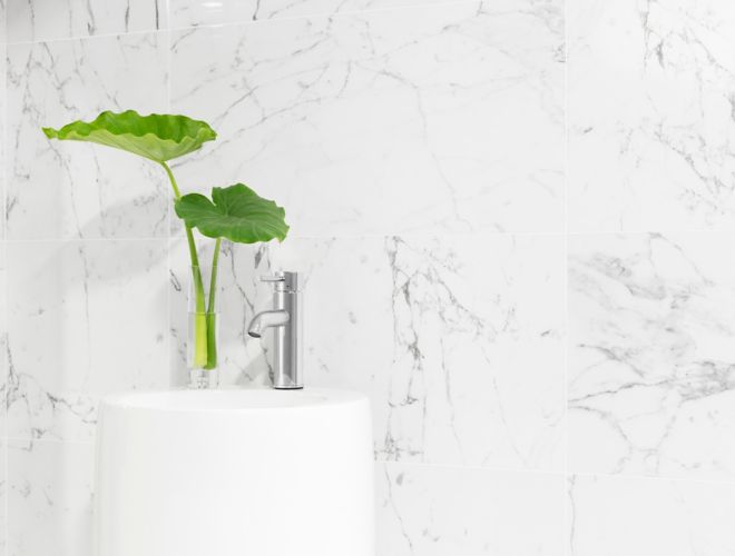 White and grey large wall tile in bathroom area.