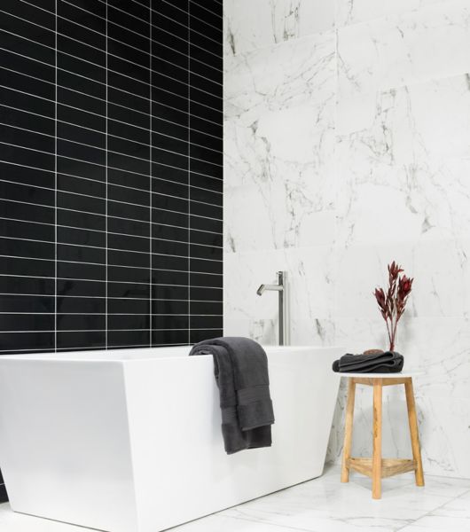 Black subway tile with white marble bathroom