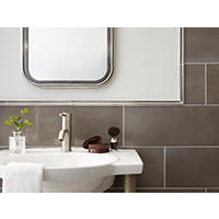 Thumbnail image of Close up view of bathroom wainscoting with a double metal pencils edge as the finishing piece.  Tile is staggered and horizontal on wall.