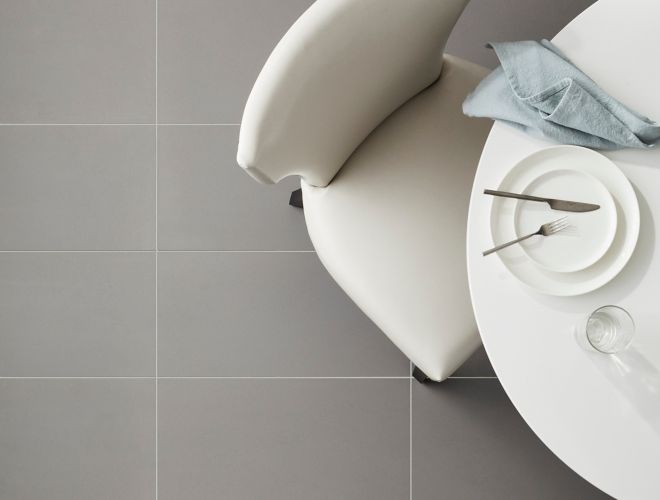 Sleek dining room floor with matte grey tile.