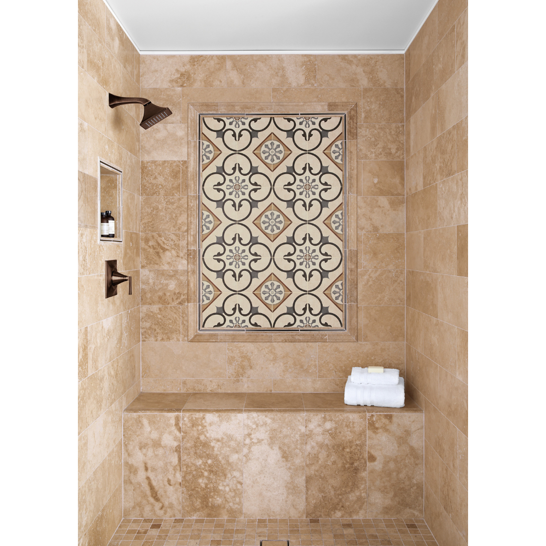 Walk in shower with Travertine stone tile and a feature frame with a porcelain patterned tile framed in both metal and stone profiles.  Recessed niche and shower bench complete the area.