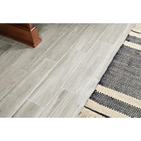 Thumbnail image of Floor shot of 12x24 inch rectangular stone look porcelain tile in matte finish. A woven rug accents the floor.