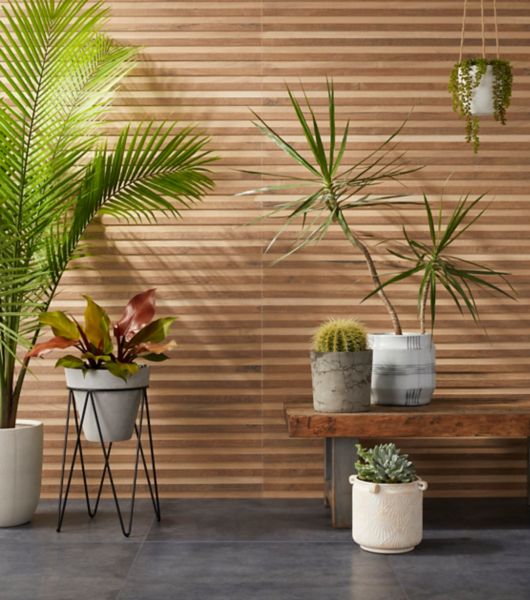 Patio area with a wood look tile with raised panels.   Patio has seating and several potted plants.