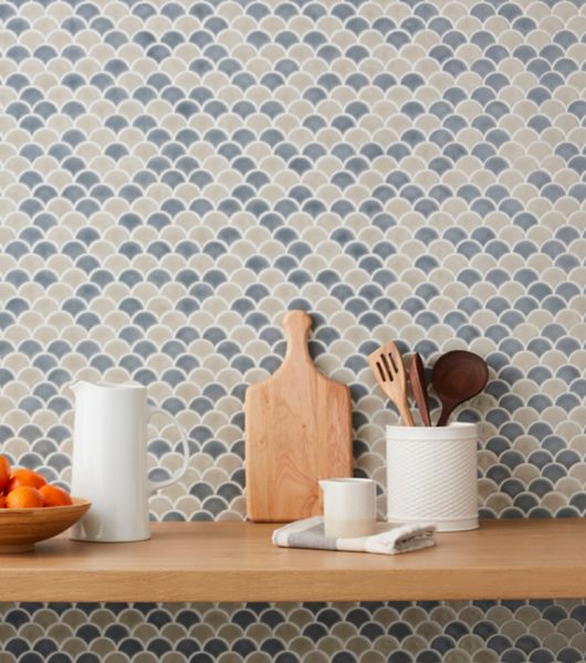 Kitchen backsplash in a crazed mosaic in a fan like pattern of tan and green.