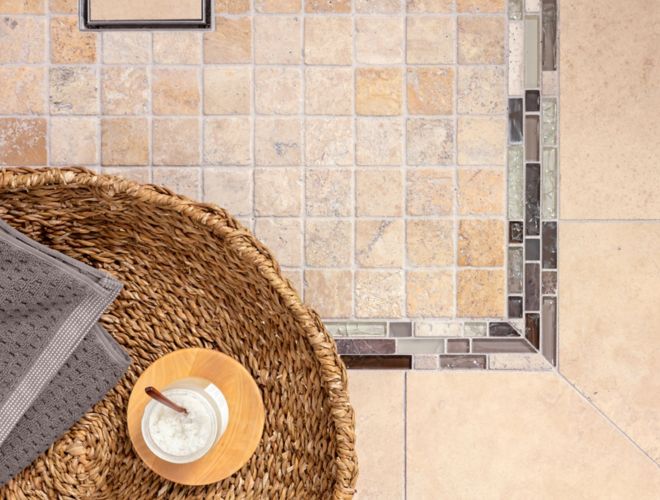 Small square travertine beige floor tile in shower.