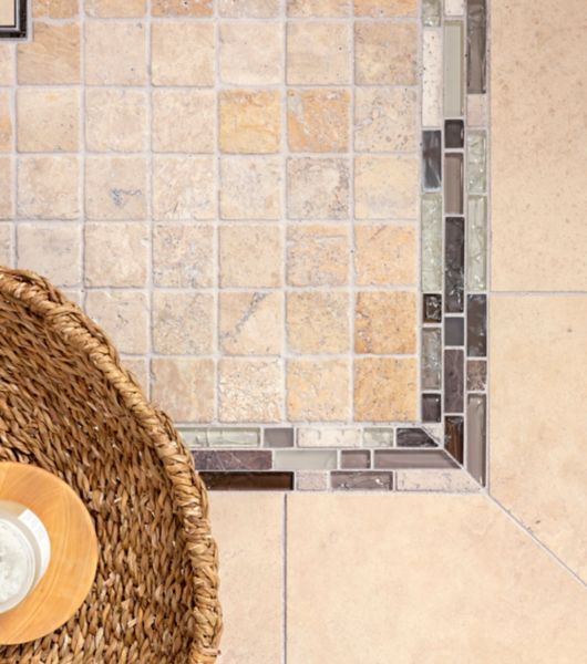 Small square travertine beige floor tile in shower.
