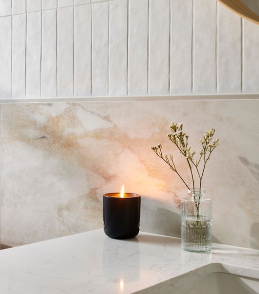 White wall and sink with a candle and small plant