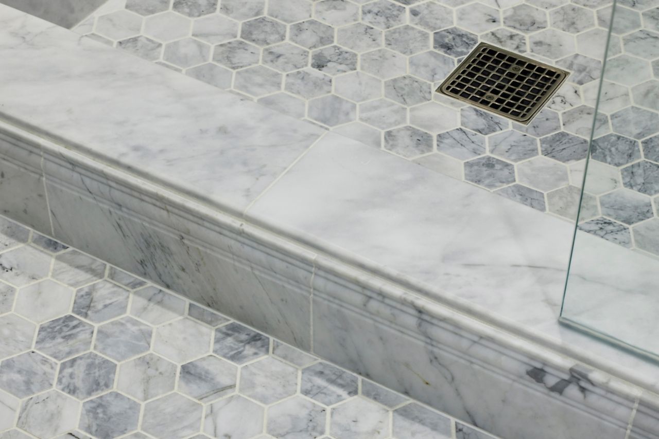 White and grey marble hexagon shower floor tile.