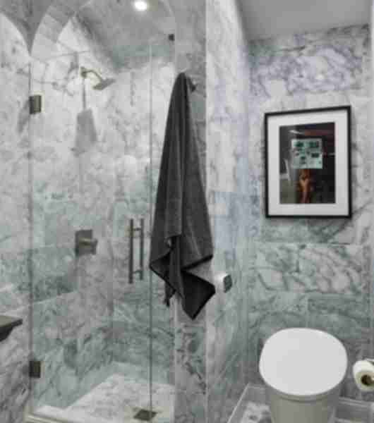 Grey bathroom with shower and painting.
