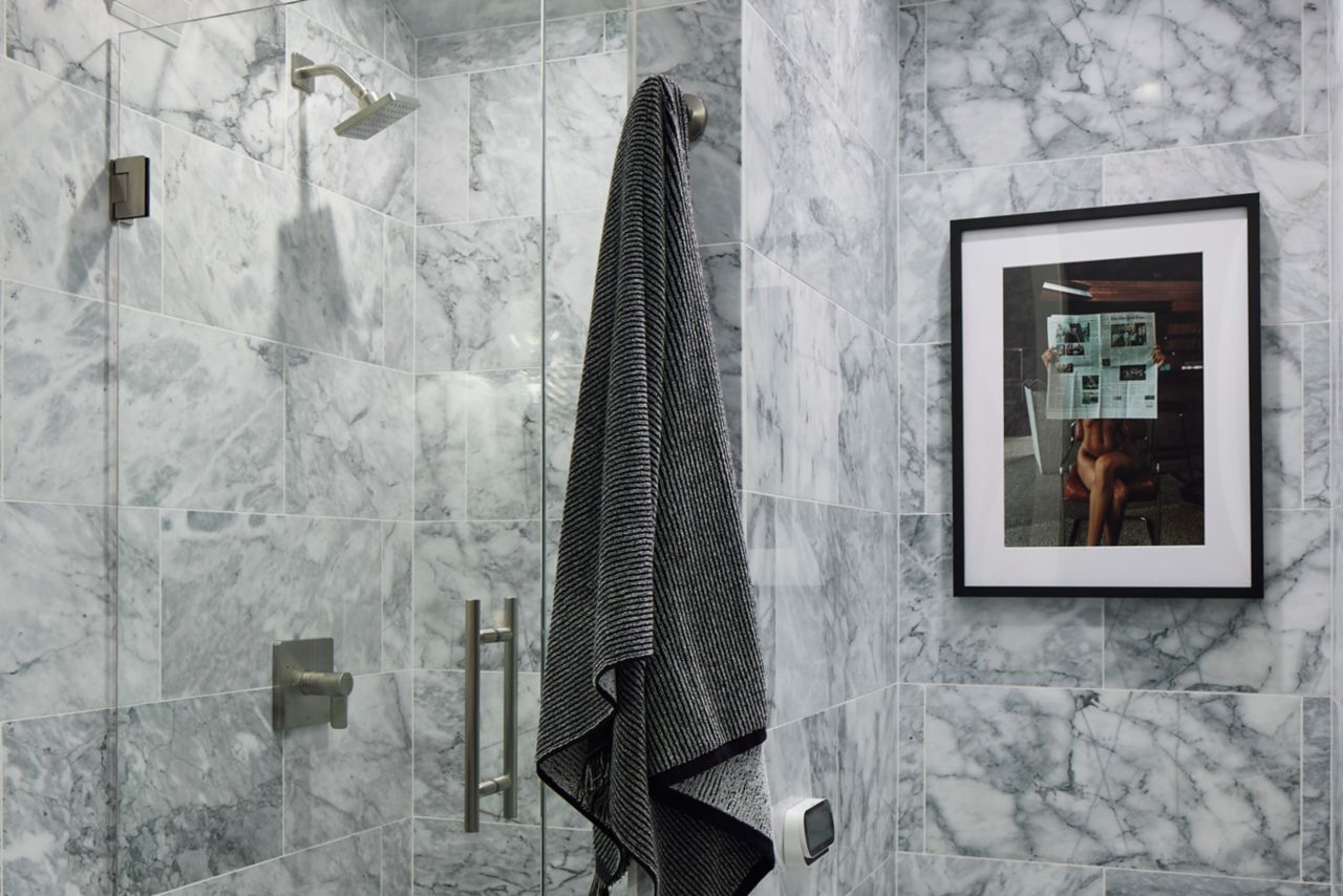 Grey bathroom with shower and painting.