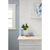 Thumbnail image of Kitchen backsplash with white picket shaped tile ran vertically above counter top.  Cabinets are white with black hardware.