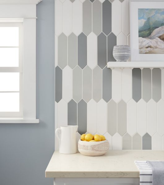 Counter with bowl of lemons and white, light grey and dark grey tiled wall