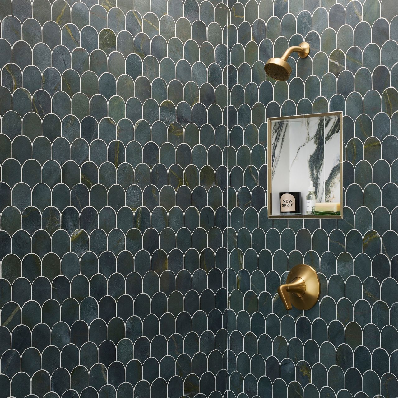 This chic shower features scalloped green marble tile and a marble-look tile with dramatic green veining and gold trim. 