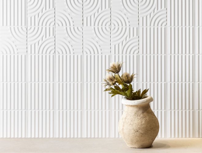 A wall with raised geometric patterned white tile.