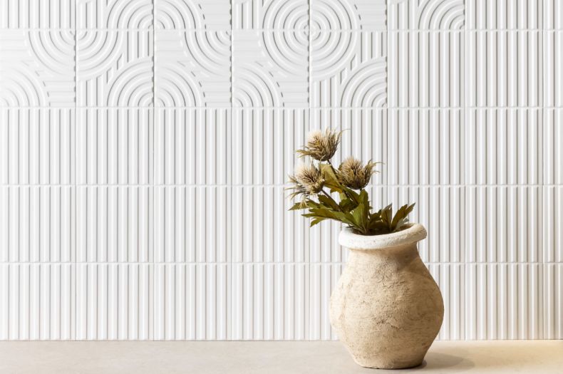 A wall with raised geometric patterned white tile.